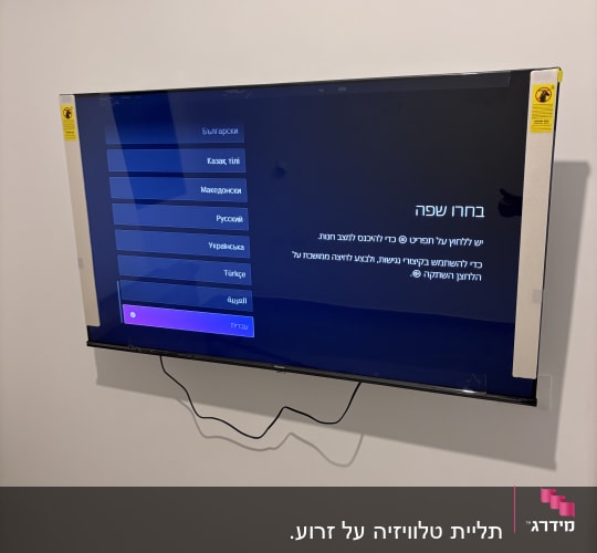 מסך טלוויזיה מותקן על קיר לבן